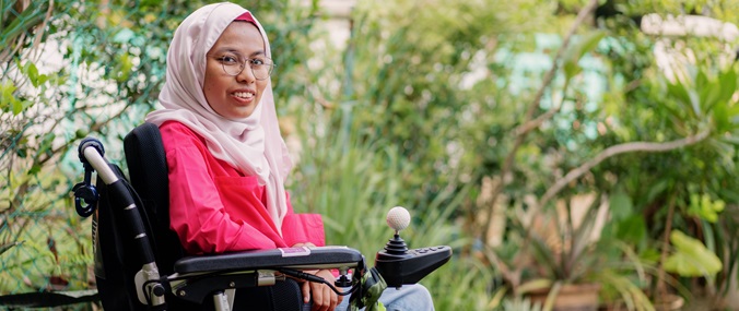 A woman in a wheelchair wearing a headscarf