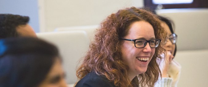 A woman laughing next to colleagues out of focus. 